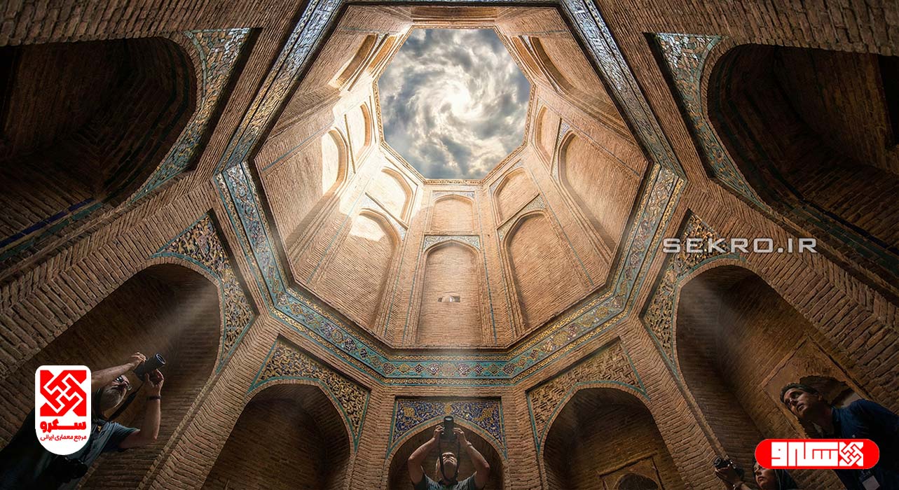 نمای دید از پایین به بالای بادگیر بلند آجری که به آسمان می‌رسد