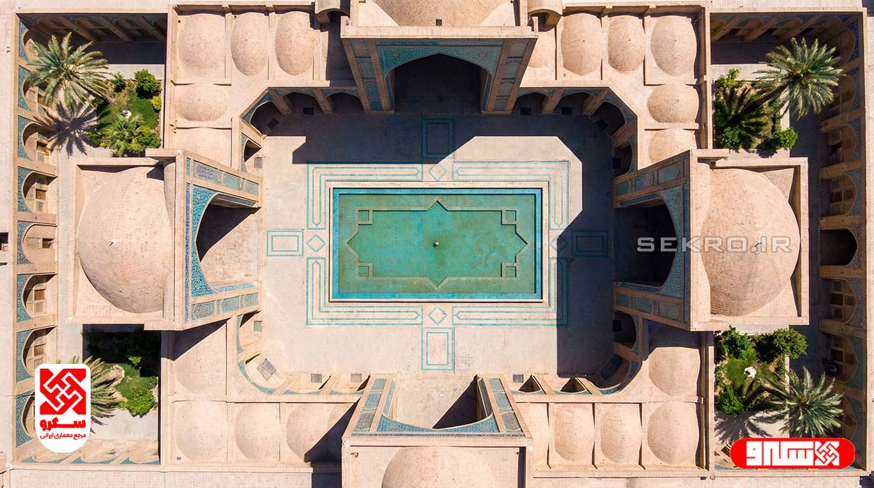 نمای دید پرنده (Drone Shot) از پلان یک کاروانسرا یا مدرسه چهارایوانی، نمایش حیاط مرکزی و چهار ایوان متقارن.