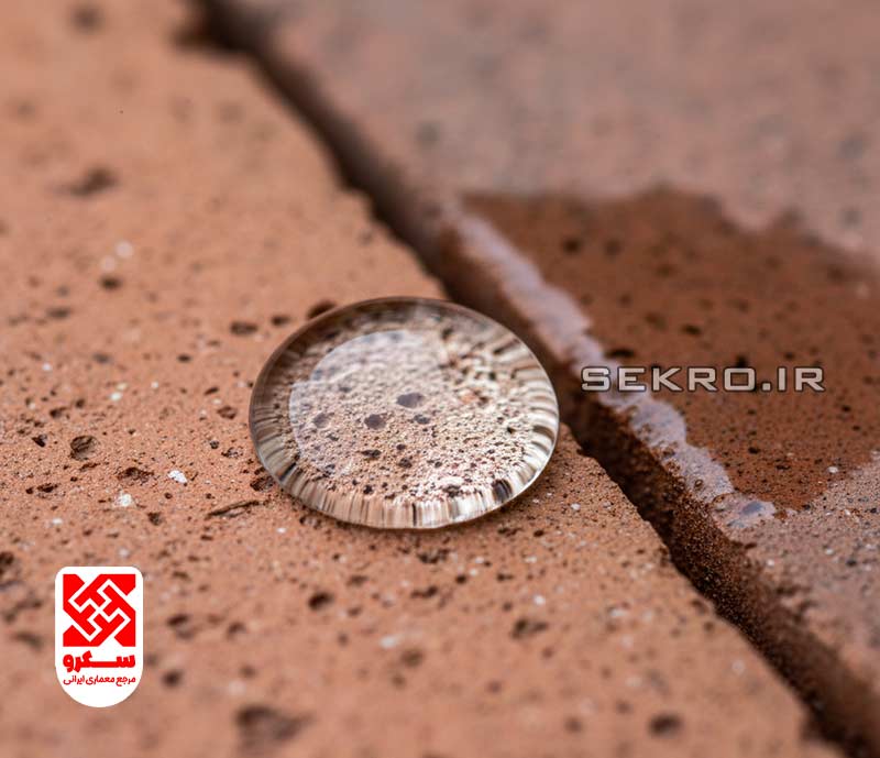 نمای ماکرو از سطح آجر که با مواد نانو پوشش داده شده و قطرات آب به صورت کروی روی آن ایستاده‌اند و جذب نمی‌شوند.